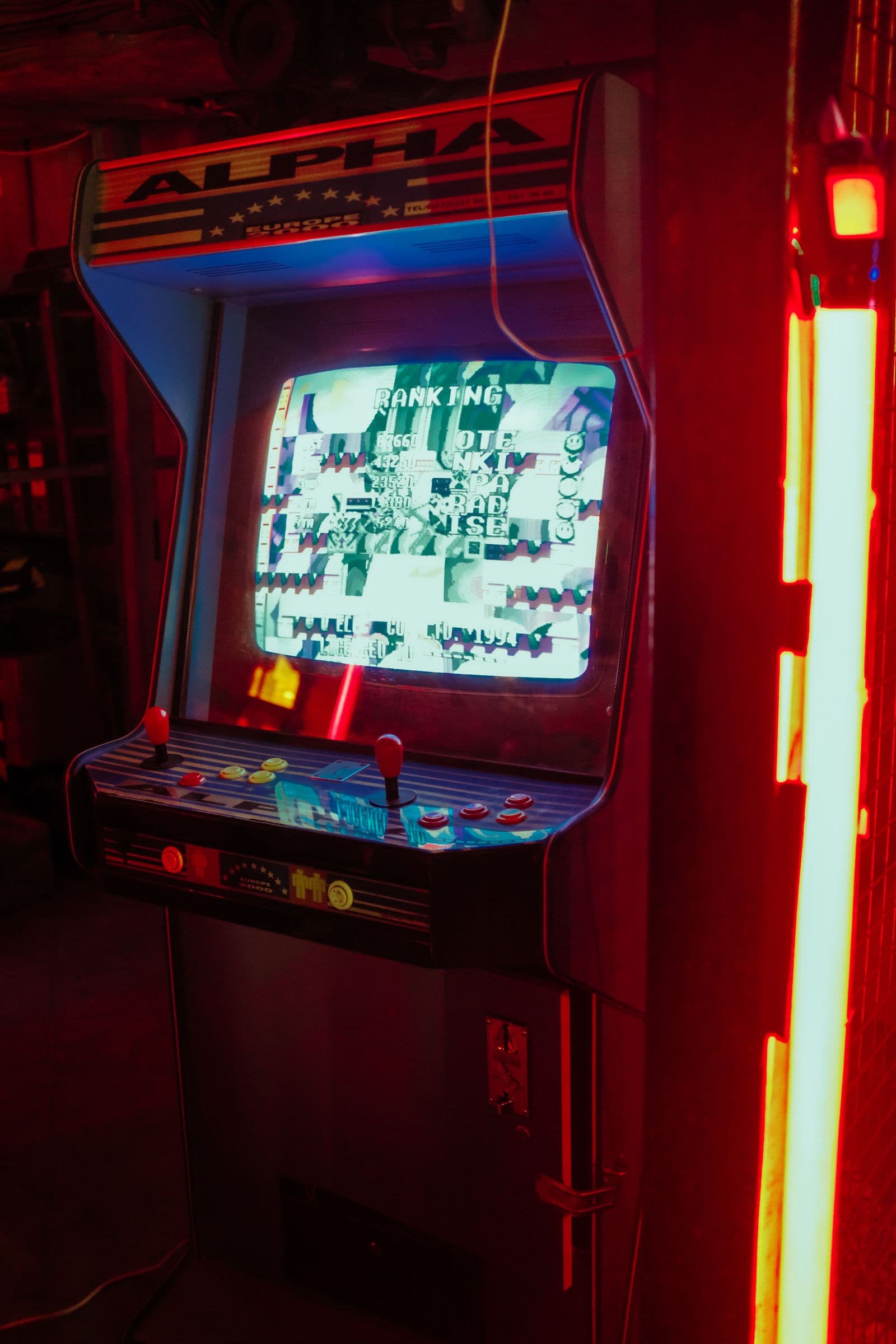 Close-up of a retro arcade cabinet with a glowing CRT and joysticks