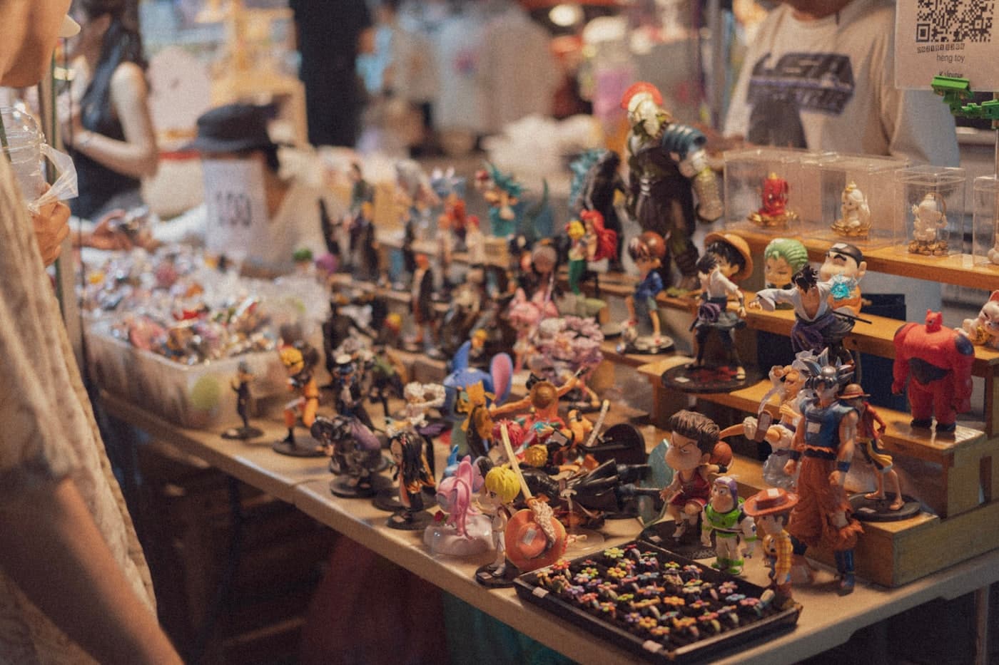 Collectible figurines and pins arranged on a crowded vendor table